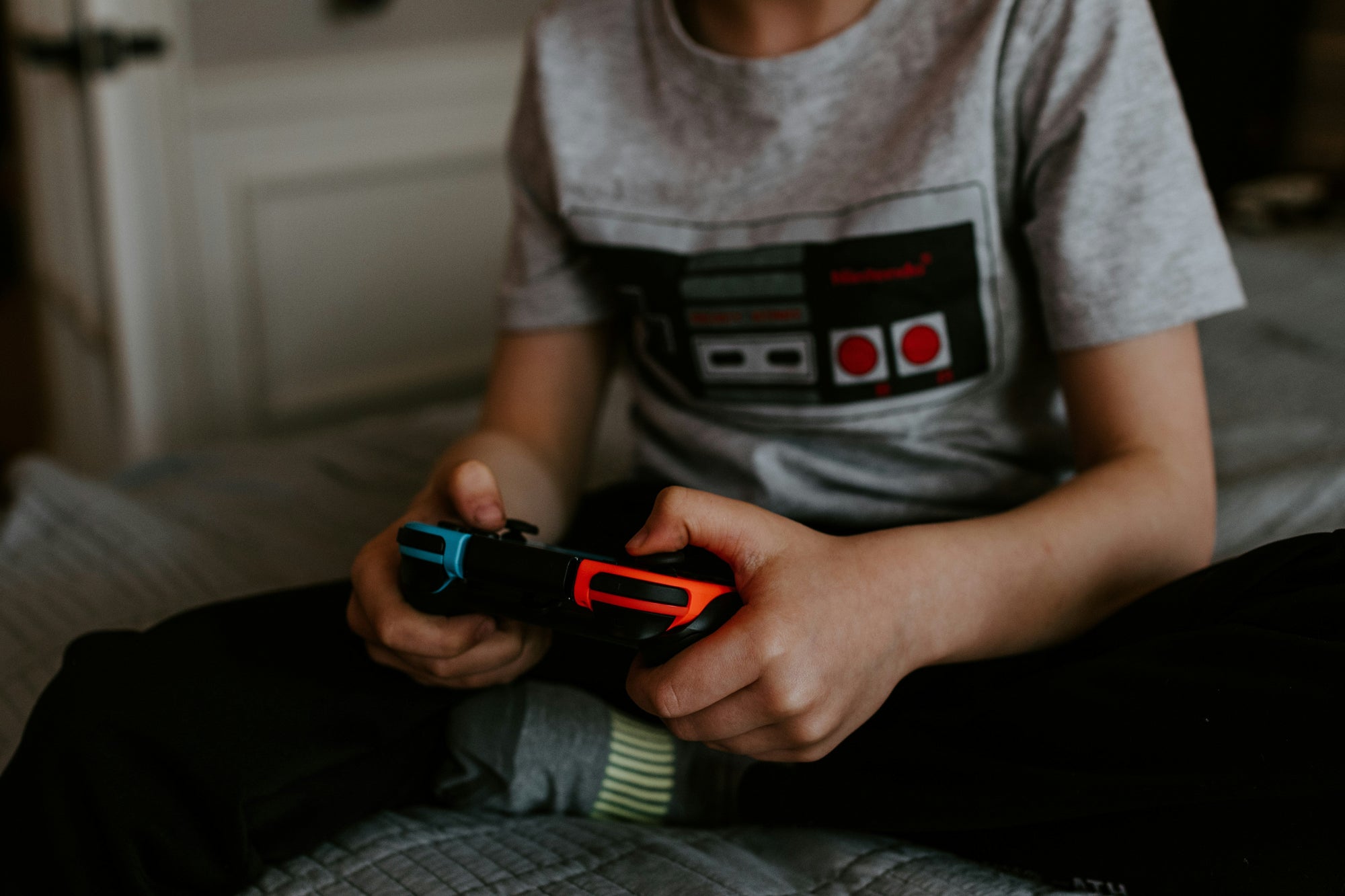 A boy sits in front of a projector screen playing a Switch2 game