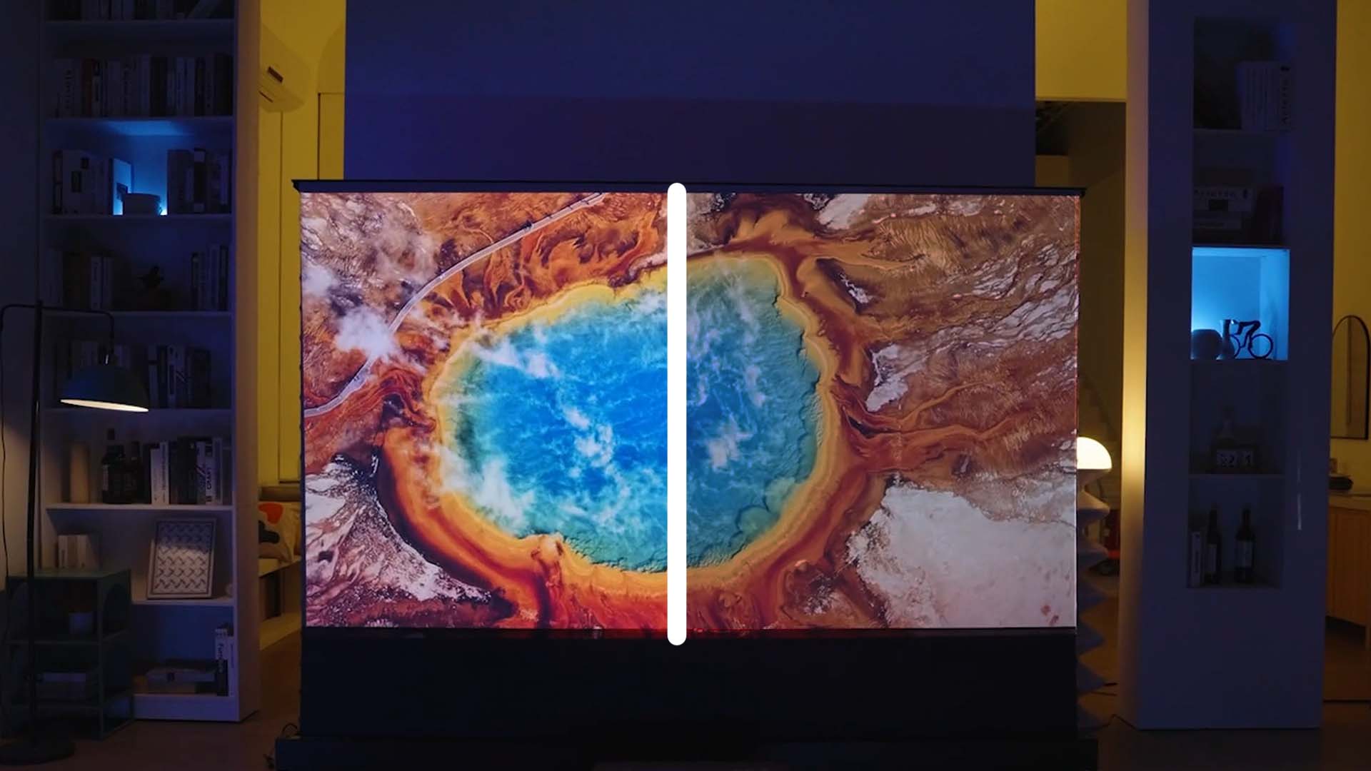 A split screen comparison of a projector displaying a vibrant hot spring, with the left side showing brighter, more saturated colors and the right side appearing dimmer and faded.