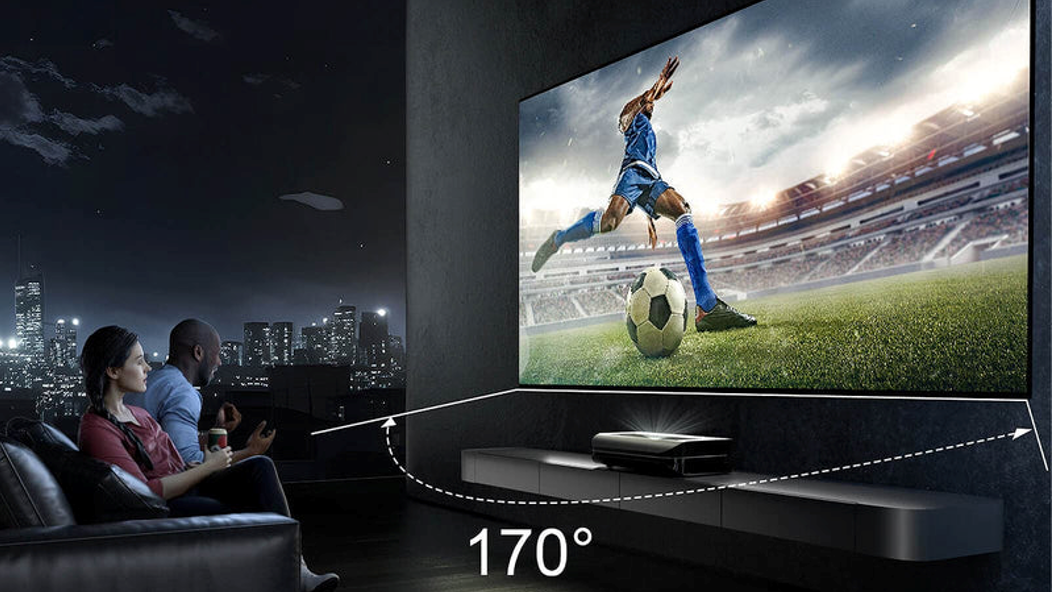A couple watching a soccer game on a large screen, highlighting the wide 170-degree viewing angle of the display in a home theater setting.