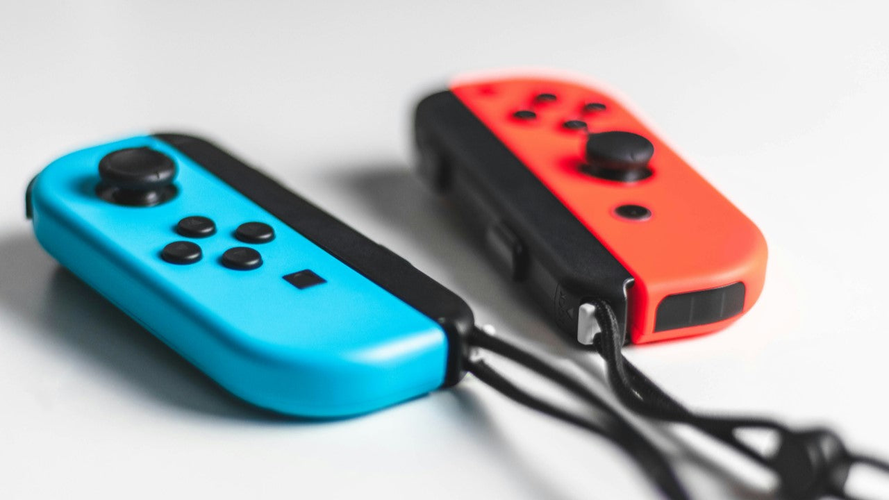 Two Nintendo Switch Joy-Con controllers, one blue and one red, representing multiplayer gaming and the best video games for couples.