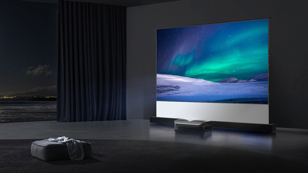A motorized floor-rising projector screen displaying a high-contrast aurora borealis image, demonstrating how specialized ambient light rejecting material enhances color vibrancy for ultra-short throw projectors.