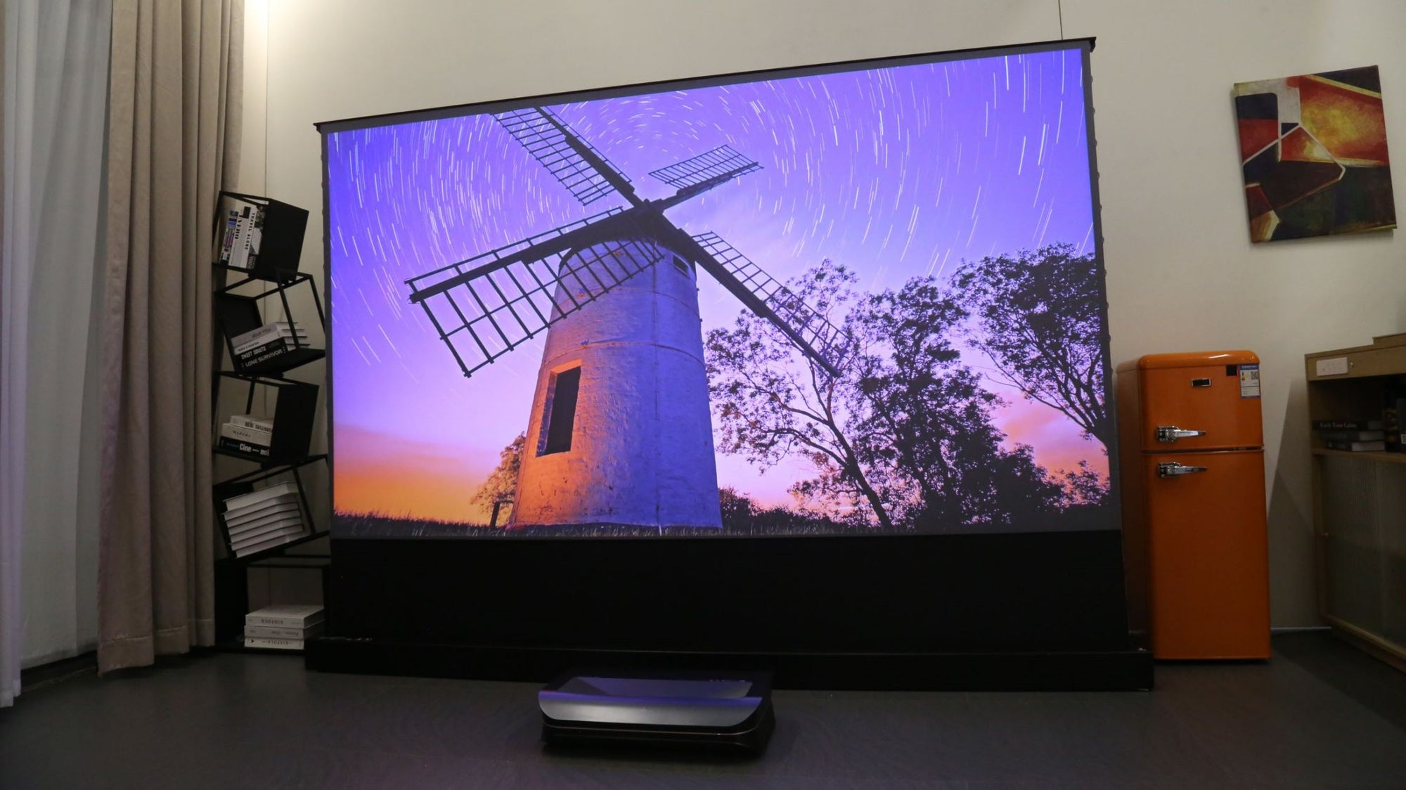 Laser projector displaying a windmill scene in home cinema