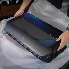 Unboxing the LTV-3500 Pro 4K 3D Triple Laser Projector from AWOL Vision, revealing its sleek design and vibrant color gradients on the casing, ideal for advanced home cinema.
