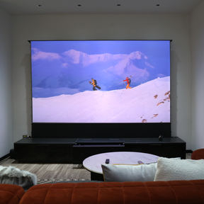 AWOL Vision Laser TV vividly projects an action-packed skiing scene on a large motorized screen, creating an immersive viewing experience.