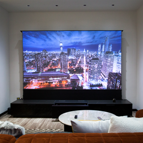 Luxurious living room featuring AWOL Vision LTV-3500 4k ust laser projector, motorized screen, and smart cabinetry displaying vibrant cityscapes for a cinematic experience.